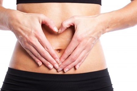 An-isolated-shot-of-a-woman-making-a-heart-sign-on-her-tummy